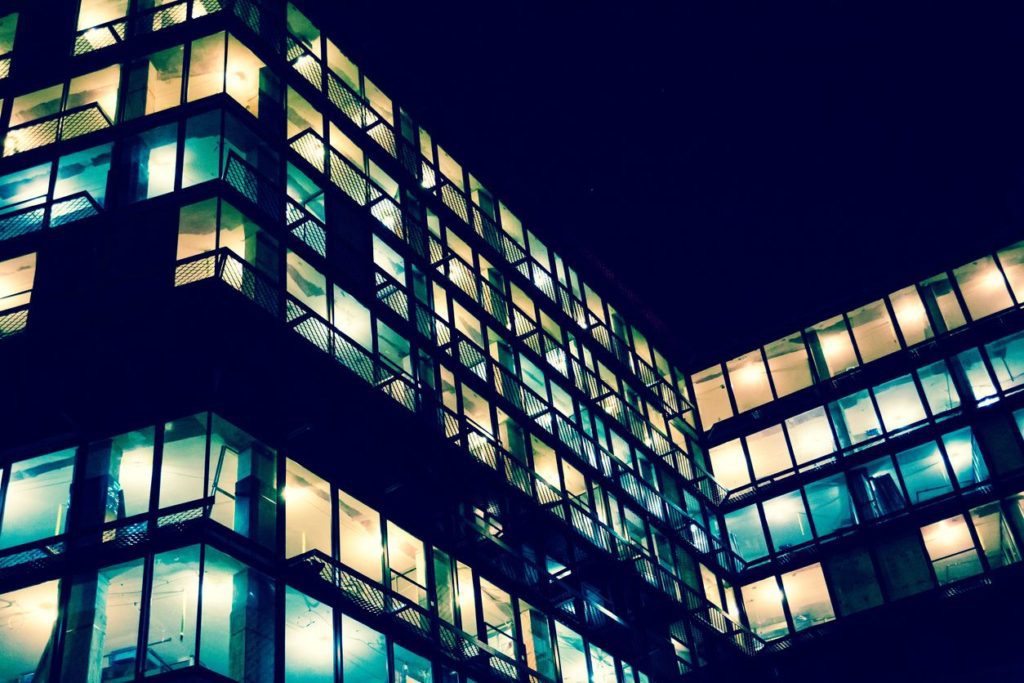 A Tall Building With Lights and Glass Windows