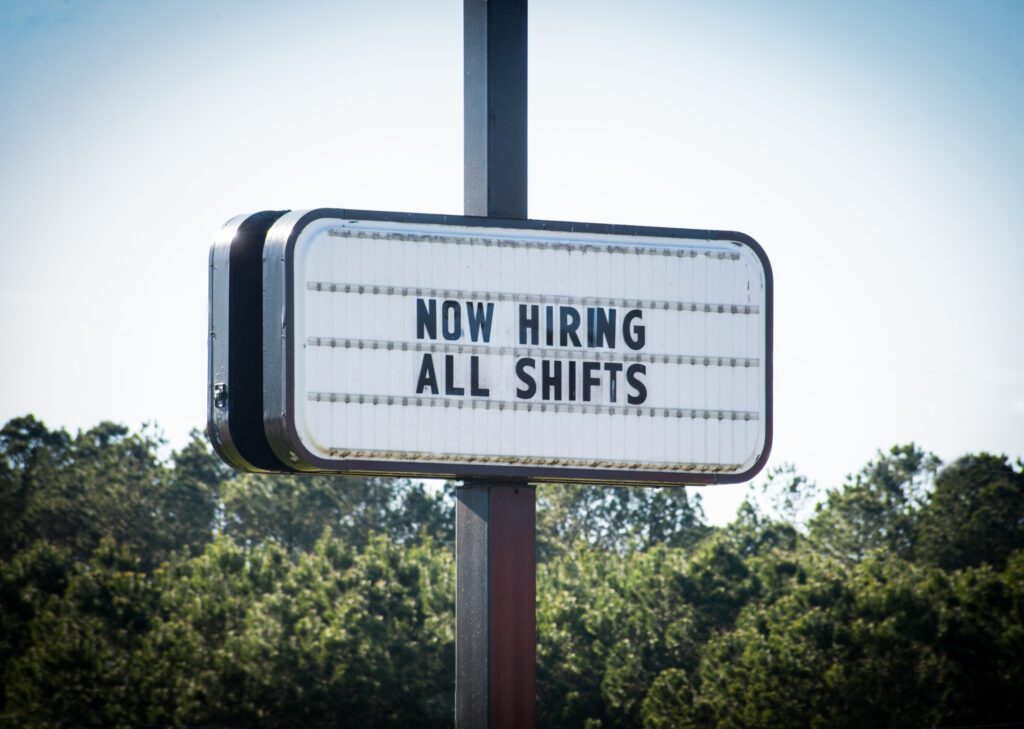 A Now Hiring All Shifts on a Board on Road