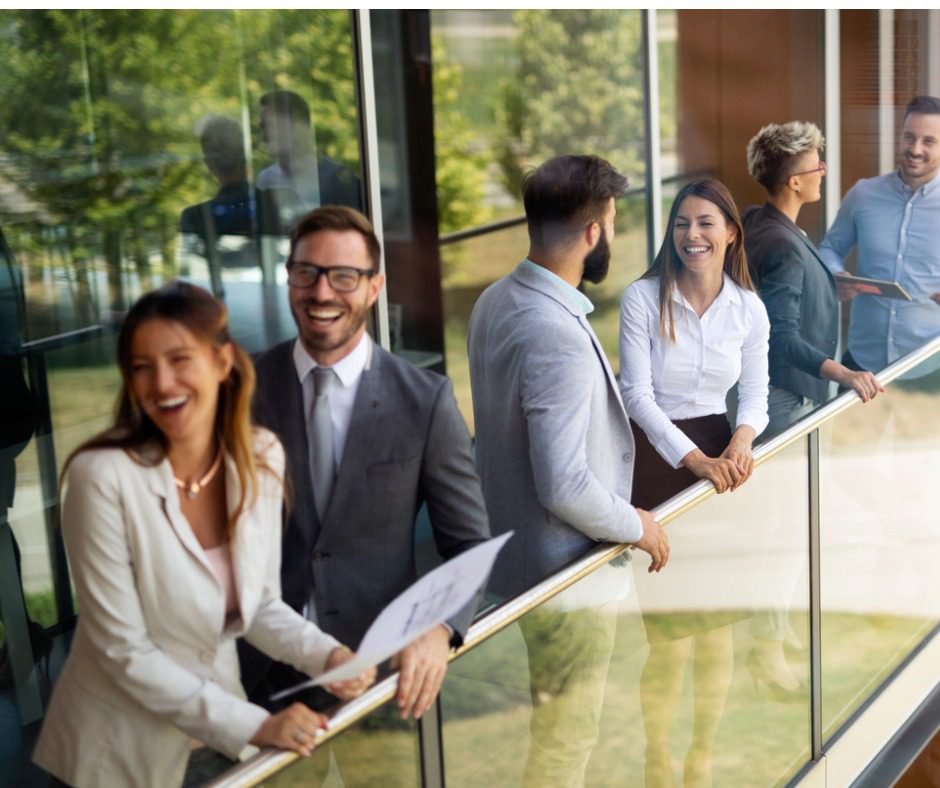 Business professionals smiling on a balcony.