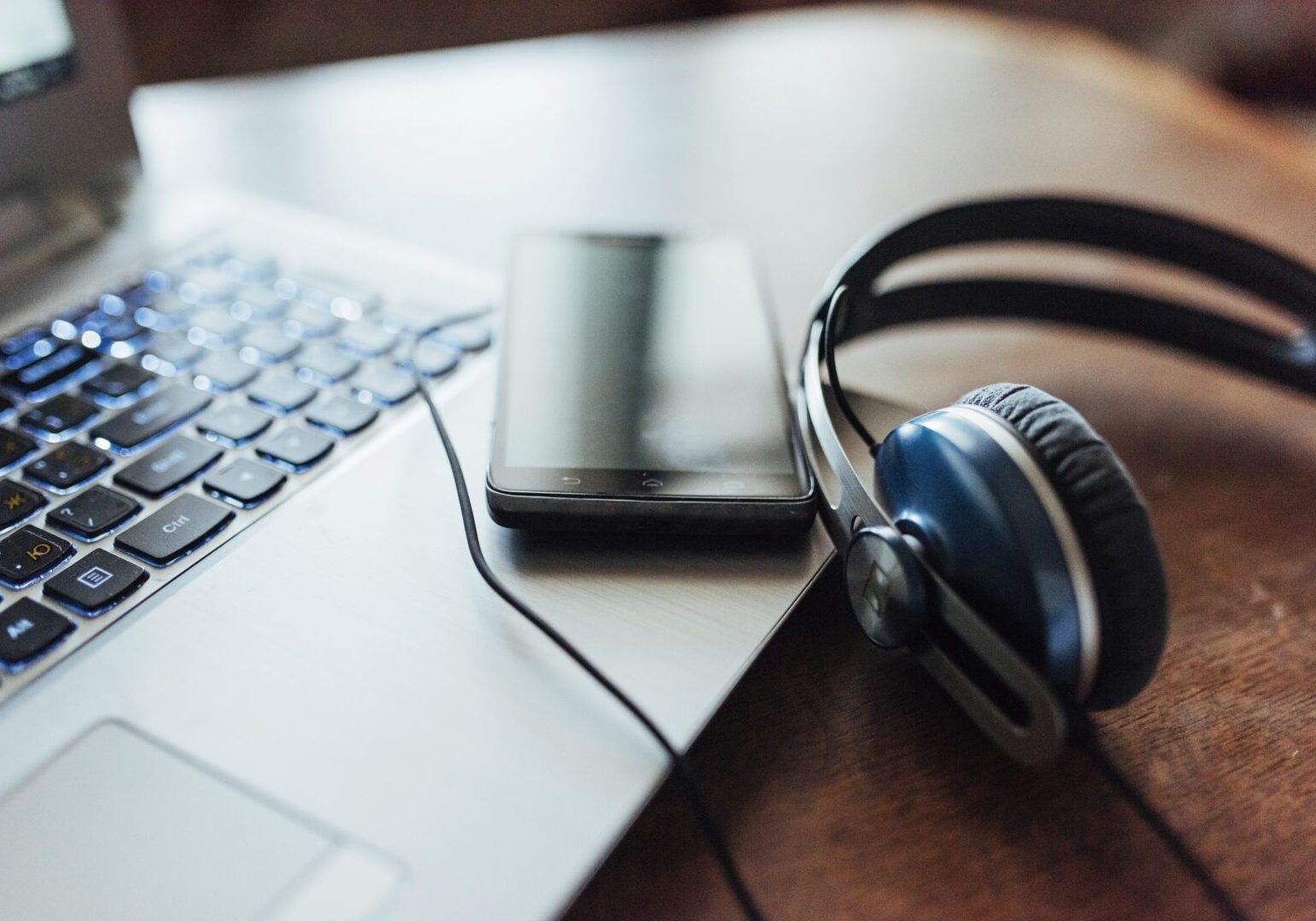 A laptop and headphones on top of a table.